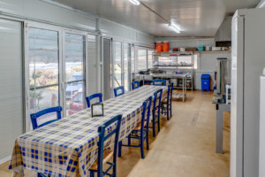 Küche mit großem Esstisch im griechischen Freizeithaus Strandlodges Panorama für Gruppenreisen.
