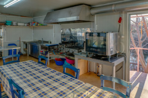Küche mit Geräten und großem Esstisch im griechischen Freizeithaus Strandlodges Panorama für Gruppenreisen.