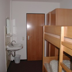 Mehrbettzimmer mit Etagenbett, Kleiderschrank und Waschbecken im Gruppenheim Jugendhaus Monschau in Deutschland.
