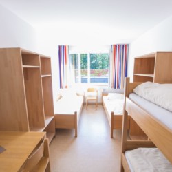 Ein Mehrbettzimmer mit Etagenbetten im deutschen Freizeitheim Gästehaus Passau für Kinder und Jugendfreizeiten.