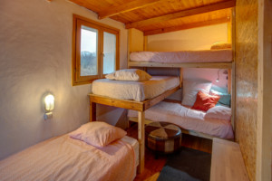 Ein Schlafzimmer mit Hochbetten im Gruppenhaus Strandlodges Panorama in Griechenland.