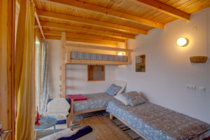 Ein Schlafzimmer mit Hochbett und Einzelbett im Freizeithaus Strandlodges Panorama in Griechenland.