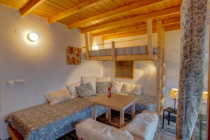 Ein Schlafzimmer mit Sitzgruppe und Hochbett im Freizeithaus Strandlodges Panorama in Griechenland.