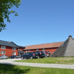 Das norwegische Sommerlager am See mit Lagerfeuerstelle.