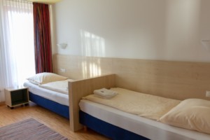 Ein Zimmer mit zwei Einzelbetten im Gruppenhaus Heringsdorf in Deutschland.