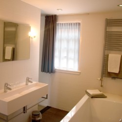 Sanitäre Anlagen mit WC und Badewanne im Gruppenhotel KOM! in den Niederlanden.