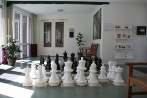 Schachspielen direkt auf dem Boden im handicapgerechten niederländischen Gruppenhaus de Jorishoeve für Menschen mit Behinderung.