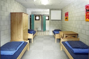 Ein Mehrbettzimmer mit Holzbetten und Kleiderschrank im niederländischen Gruppenhaus Benelux für Kinder und Jugendreisen.