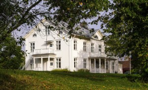 Das schwedische Freizeithaus Berga Gård liegt auf einem grünen Hügel.