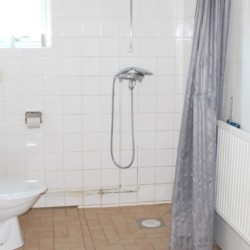Sanitäre Anlagen mit Dusche, WC und Fenster im Gruppenhaus Tygegården in Schweden.