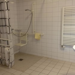 Barrierefreie sanitäre Anlagen mit Duschstuhl im Freizeitheim Hotel Rügenblick in Deutschland.