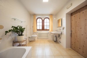 Barrierefreie sanitäre Anlagen mit WC und Waschbecken im italienischen Freizeithaus Hotel Masatsch für Kinder und Jugendreisen.