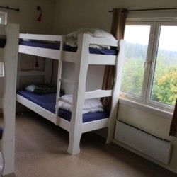 Das Schlafzimmer im norwegischen Freizeitheim Haraset hat einen Ausblick auf dem Wald